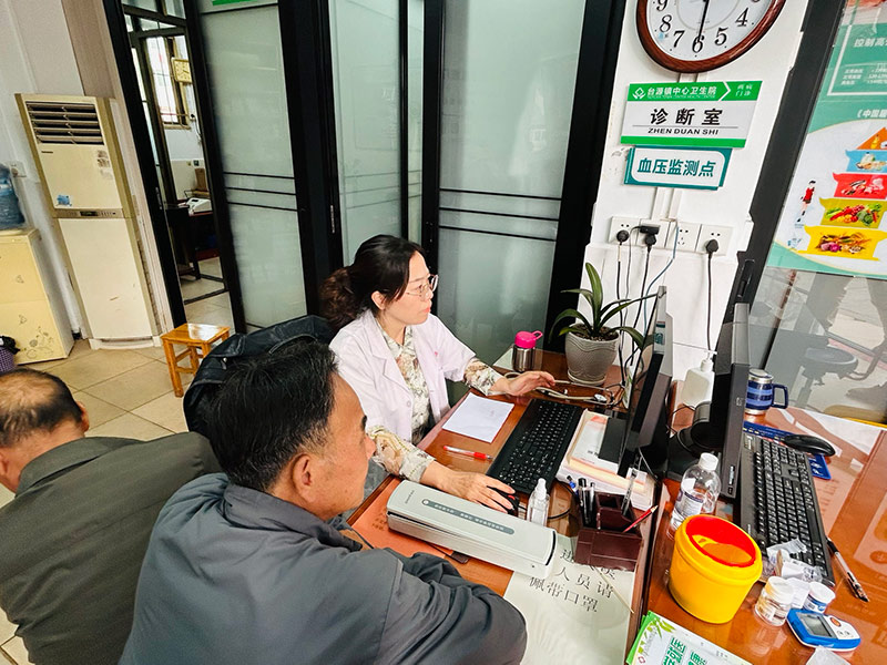 台源寺社区卫生室内医生易平英正在给患者看病。何彪摄